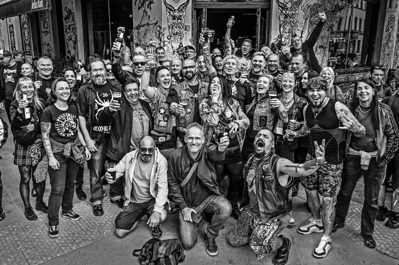 Schwarz-Weiß-Gruppenfoto einer großen Punk-Crew vor einem Club