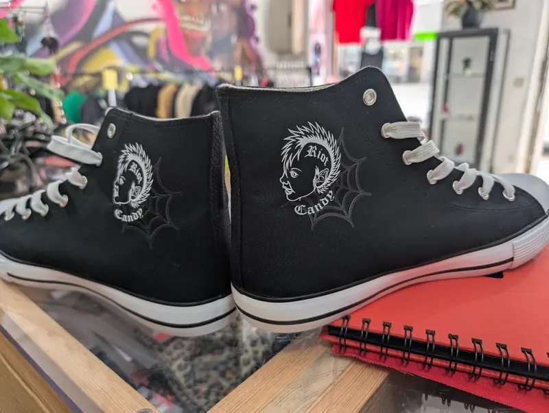 Schwarze Sneaker mit aufgedrucktem Riot Candy Maskottchen
