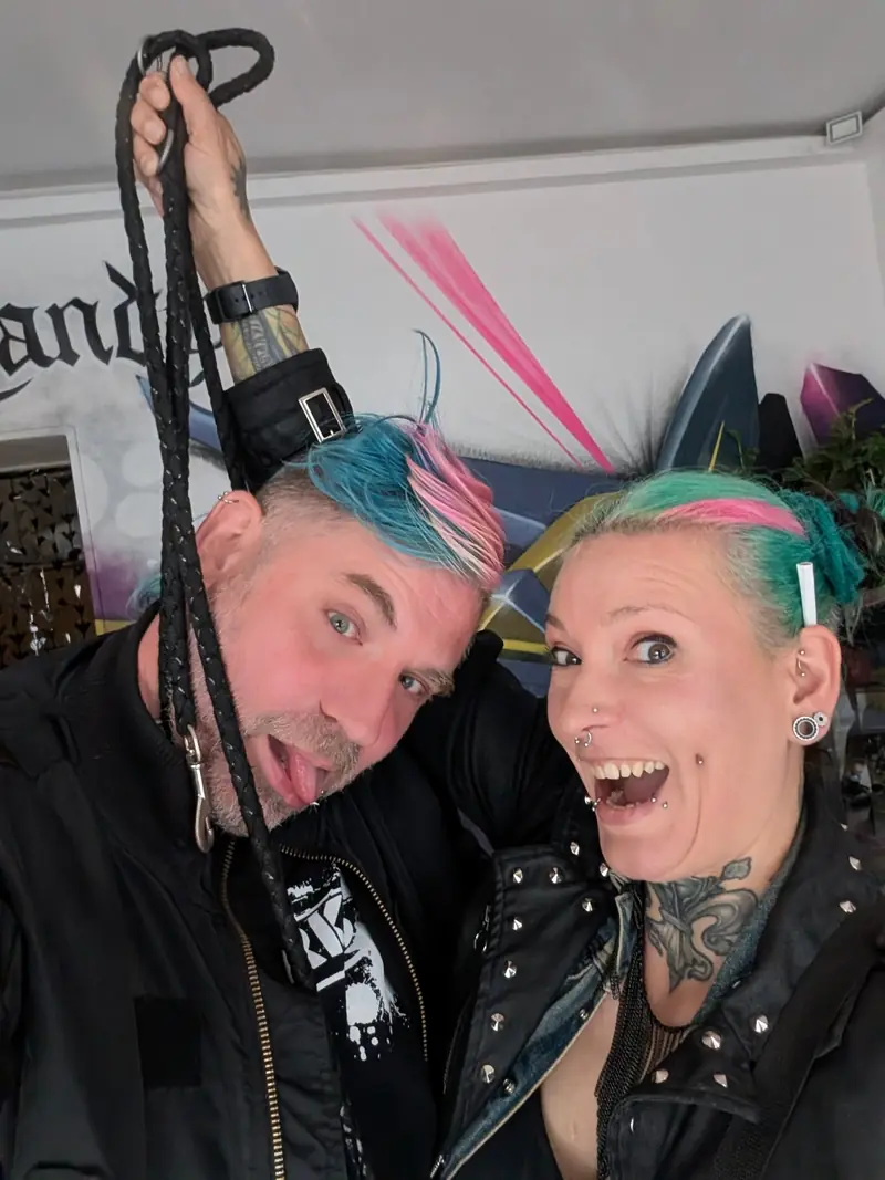 Mann und Frau mit bunten Haaren albern vor der Kamera herum