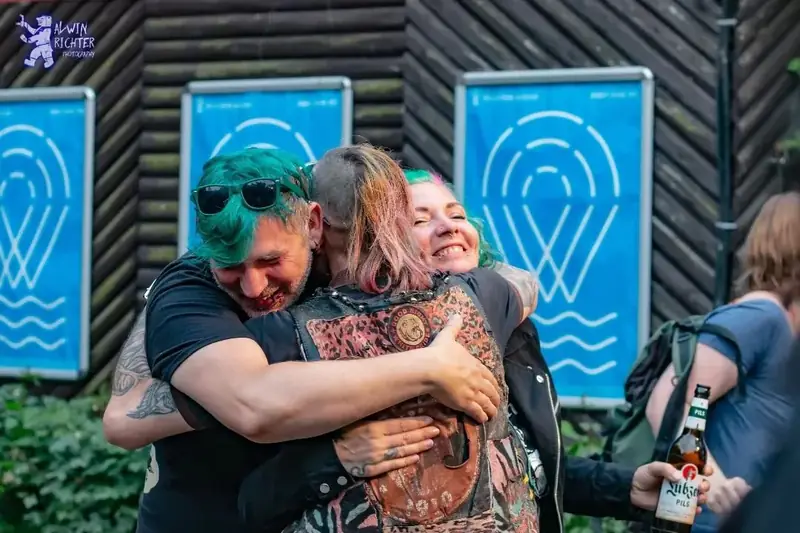 Zwei Menschen umarmen sich herzlich auf einem Festival
